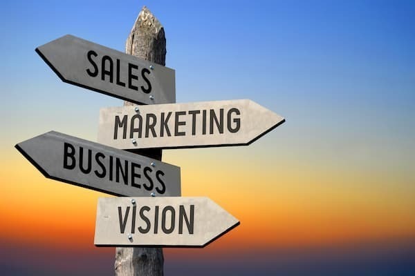 Signpost With Arrows That Say Sales Marketing Business Vision